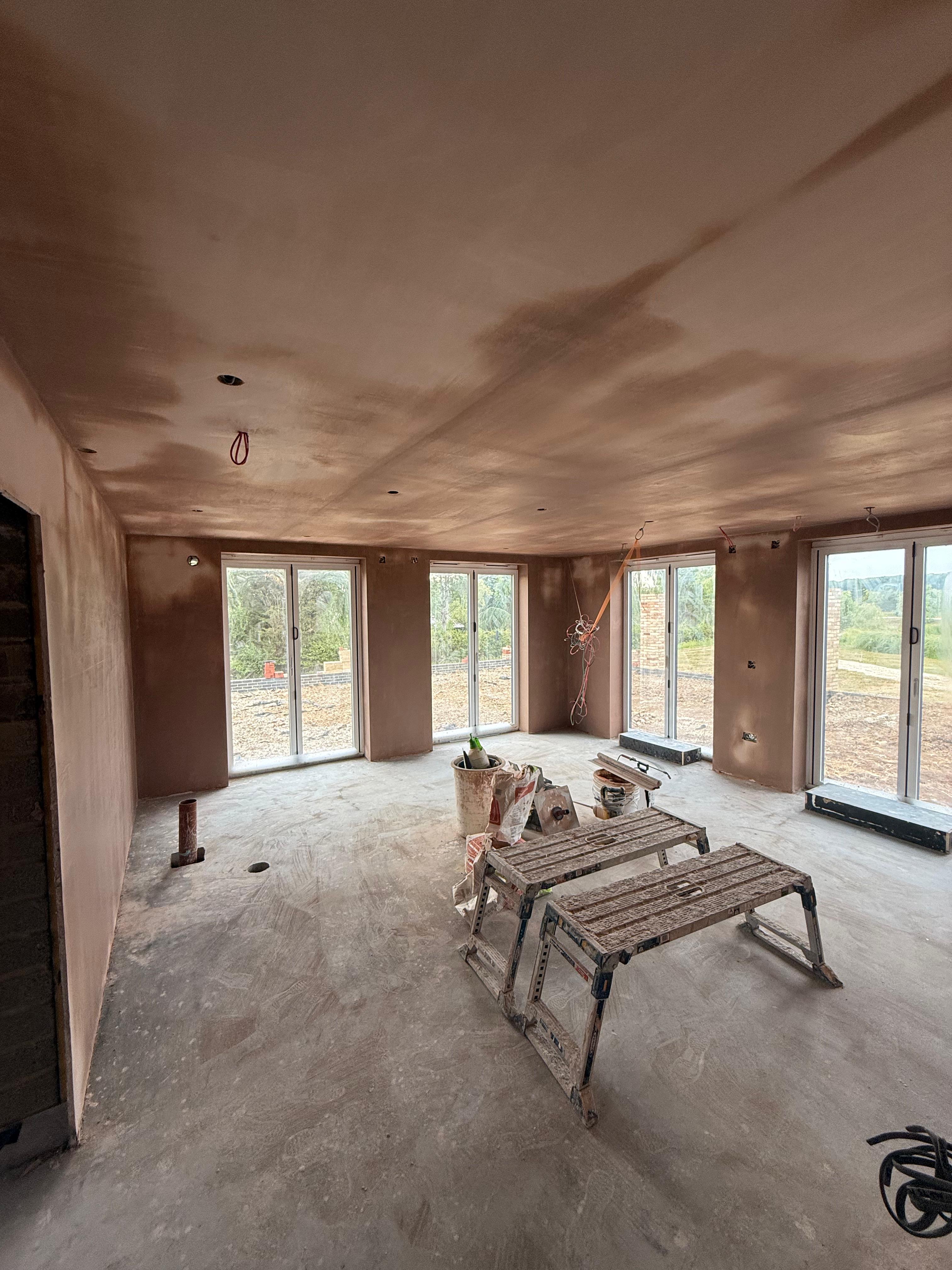 Large room plastering in progress — new build