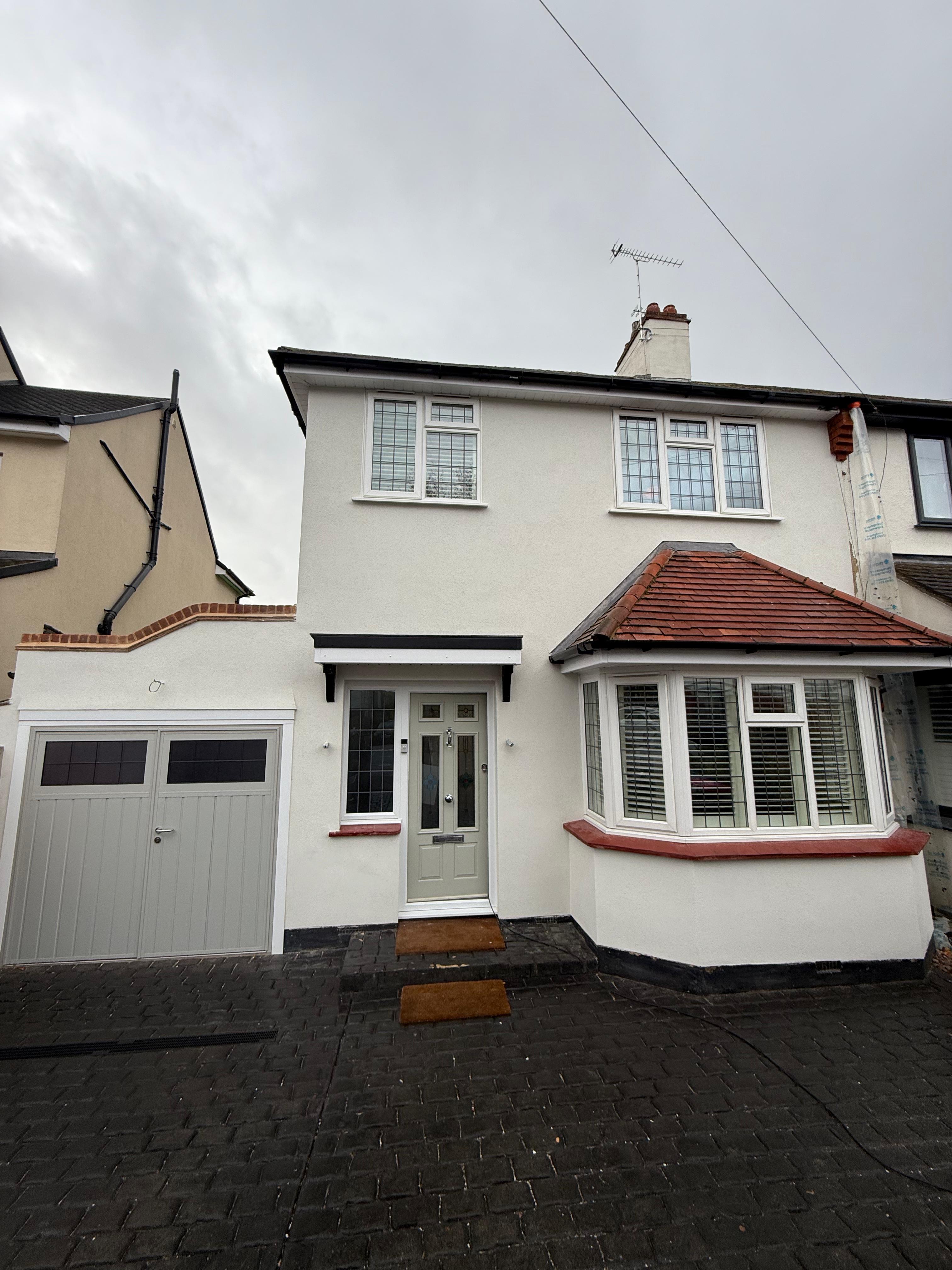 White rendered house with garage — completed project